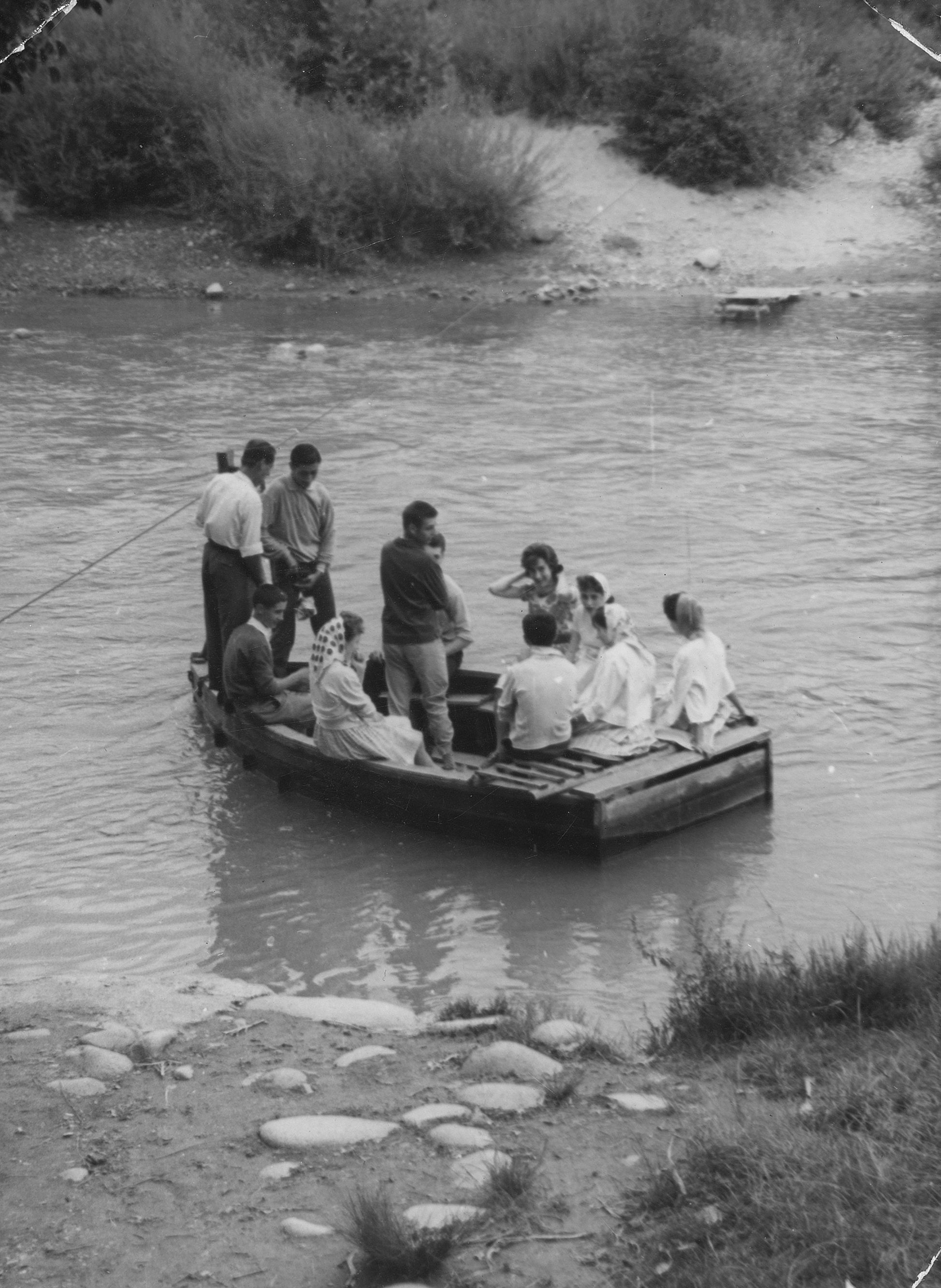 Grup de persones travessant el riu Ter amb una barca